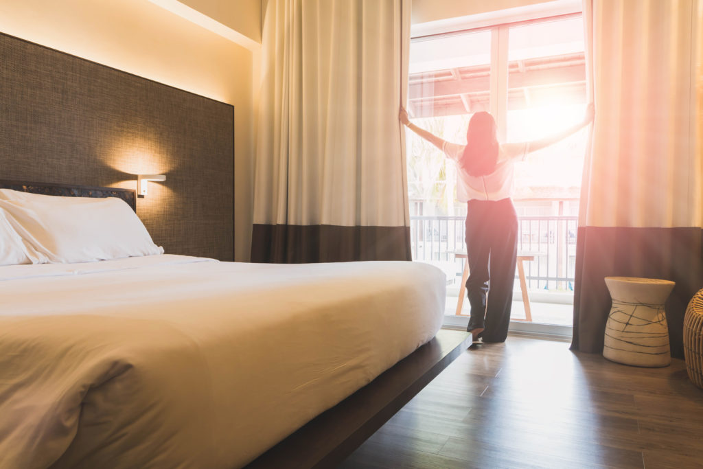 Kategoribild för sängar, kvinna vaknar upp i hotellsäng